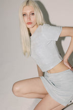 Model wearing blue terry midi skirt with "Marriage Material™" graphic near hem, close-up pose