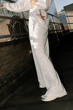 Detail view of 'Bride' text on white terry pants, styled on model